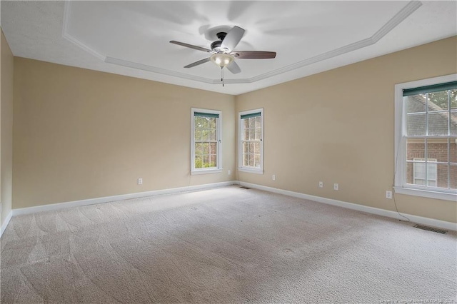 unfurnished room with light colored carpet, a raised ceiling, visible vents, and baseboards