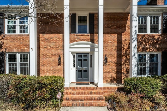 doorway to property with brick siding