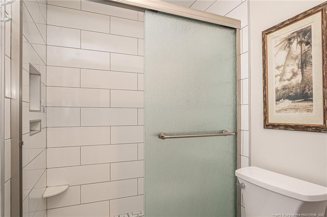 bathroom with a shower stall and toilet