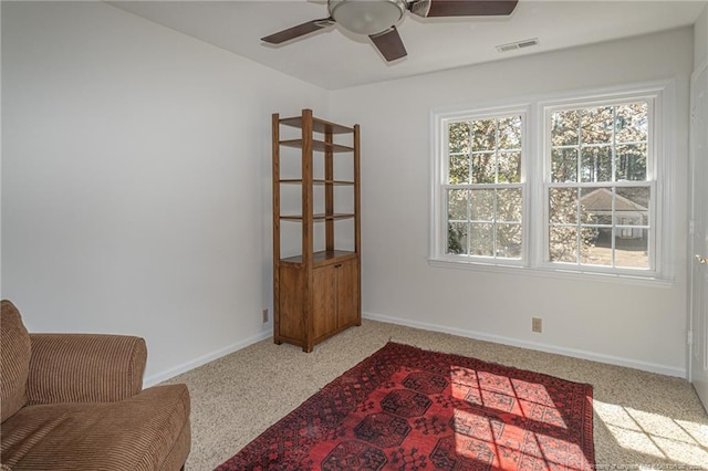 living area with visible vents, ceiling fan, baseboards, and carpet floors