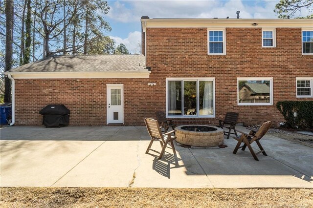 back of house with a patio, brick siding, and an outdoor fire pit