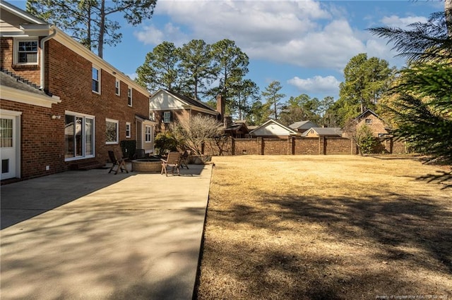 view of yard featuring a patio, fence, and an outdoor fire pit