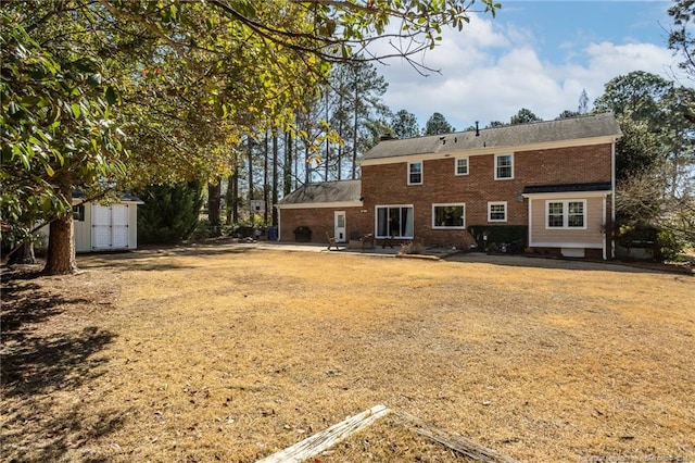 back of house featuring an outbuilding, brick siding, and a chimney