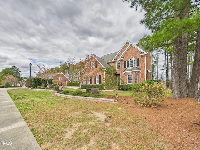 traditional-style house with brick siding and a front yard