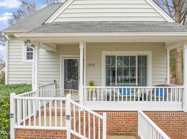 exterior space featuring covered porch and a shingled roof