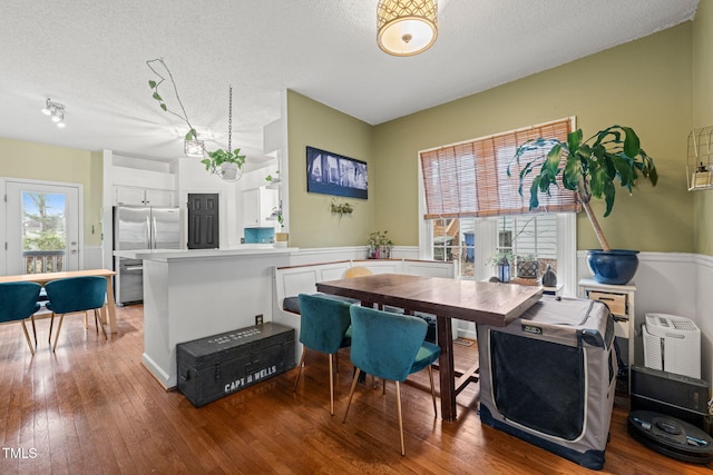 dining area featuring a textured ceiling and hardwood / wood-style flooring