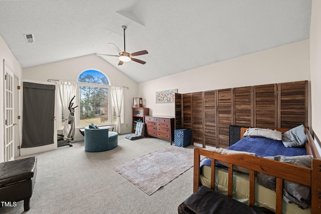 carpeted bedroom with lofted ceiling, a textured ceiling, visible vents, and a ceiling fan