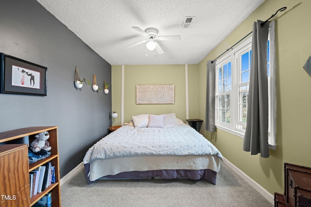 carpeted bedroom with baseboards, a ceiling fan, and a textured ceiling