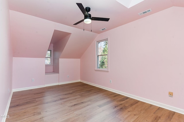 bonus room with vaulted ceiling, visible vents, and wood finished floors