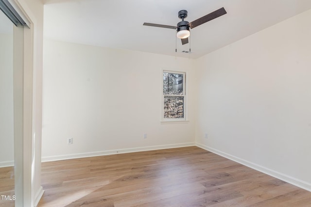 empty room with visible vents, light wood-style floors, baseboards, and ceiling fan