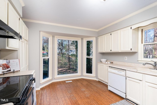 kitchen featuring ornamental molding, a sink, light countertops, dishwasher, and wall chimney exhaust hood