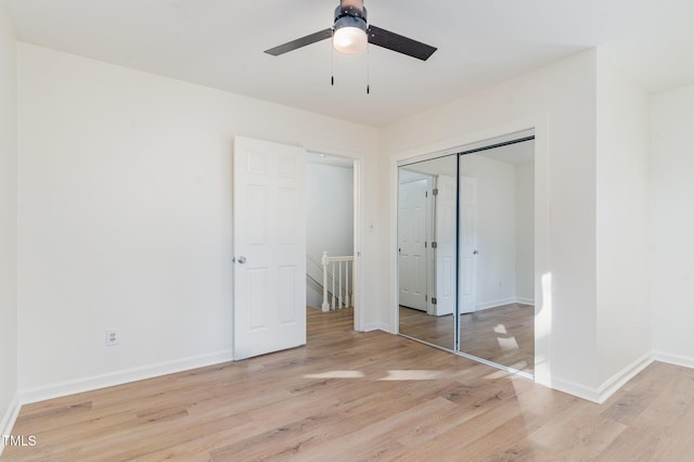 unfurnished bedroom featuring light wood-type flooring, baseboards, a closet, and a ceiling fan