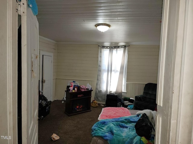 carpeted bedroom featuring wood walls