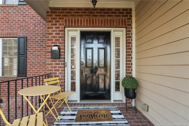 doorway to property featuring brick siding