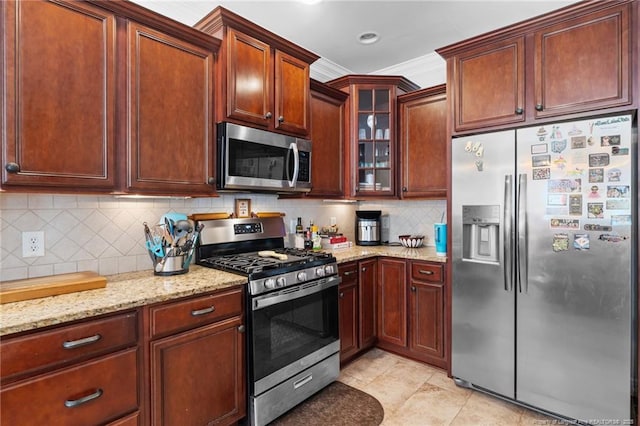 kitchen with stainless steel appliances, backsplash, light stone countertops, glass insert cabinets, and crown molding