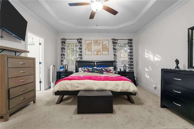 bedroom with a raised ceiling, light colored carpet, and multiple windows