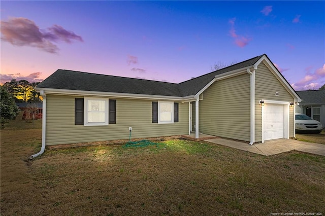 ranch-style house featuring a garage, driveway, and a front lawn