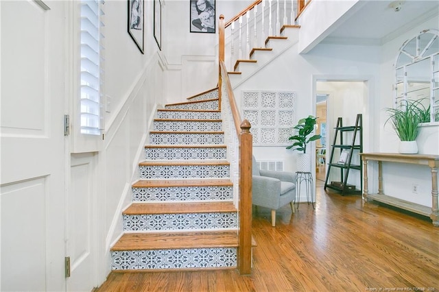 staircase featuring visible vents and wood finished floors