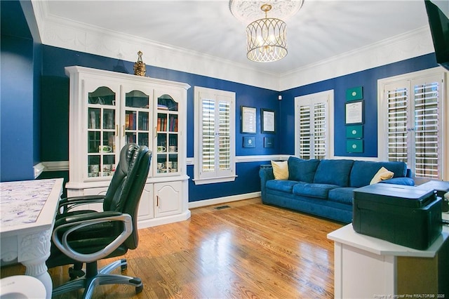 office space featuring baseboards, visible vents, wood finished floors, crown molding, and a notable chandelier