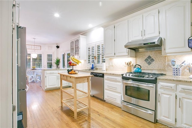 kitchen featuring stainless steel appliances, white cabinetry, a sink, light wood-type flooring, and under cabinet range hood