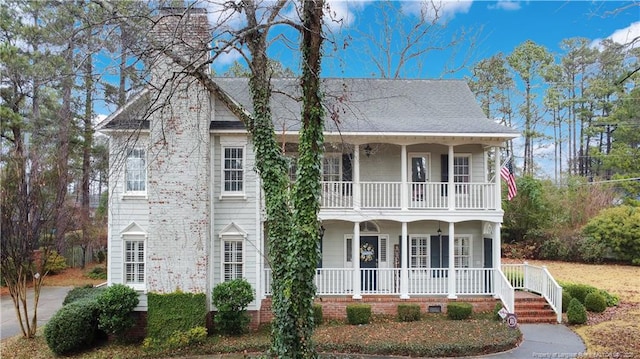 view of front of house featuring a balcony, a porch, and roof with shingles