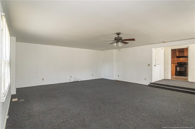 carpeted spare room featuring a ceiling fan