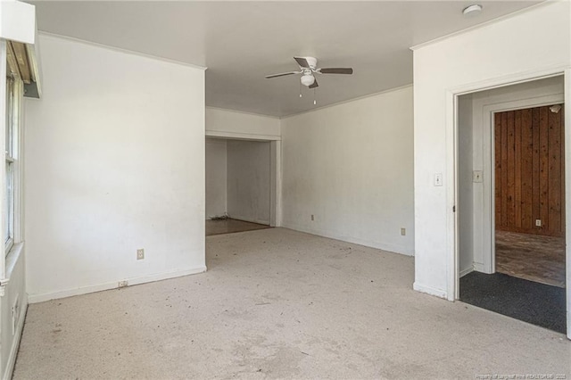 carpeted spare room featuring a ceiling fan