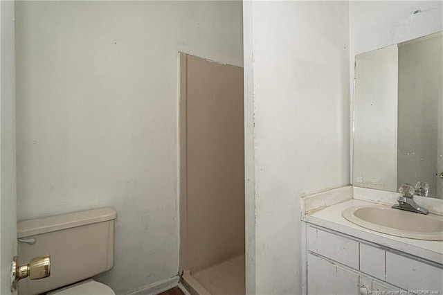 full bathroom with a stall shower, vanity, and toilet