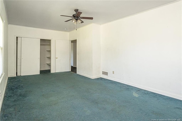 unfurnished bedroom with a closet, visible vents, dark carpet, a ceiling fan, and baseboards