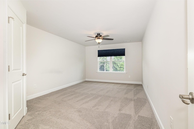 carpeted empty room featuring ceiling fan and baseboards