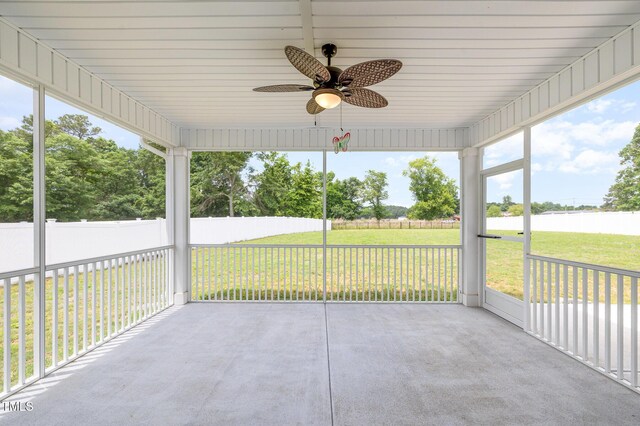 unfurnished sunroom with a ceiling fan