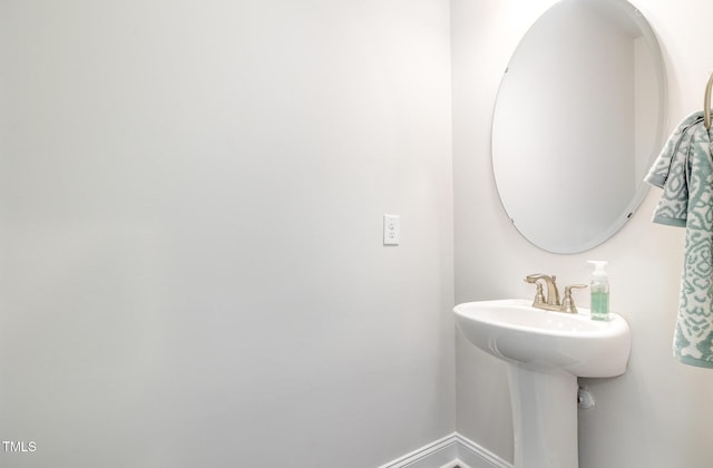 bathroom featuring baseboards and a sink