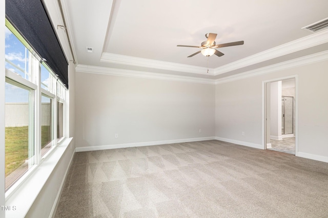 spare room featuring carpet floors, a ceiling fan, crown molding, a tray ceiling, and baseboards