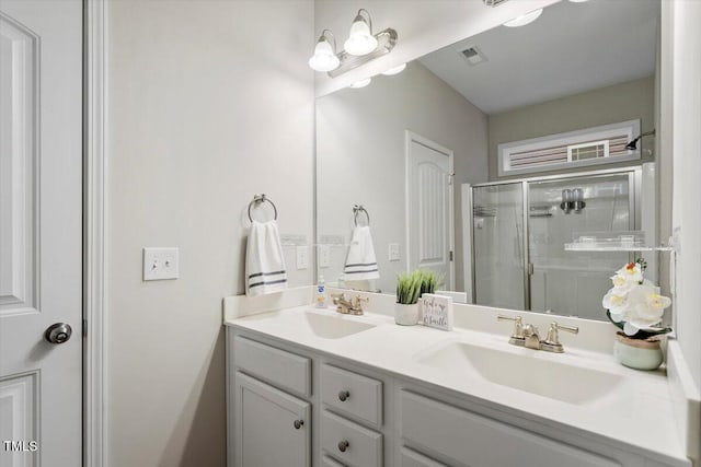 full bathroom featuring double vanity, a shower stall, visible vents, and a sink