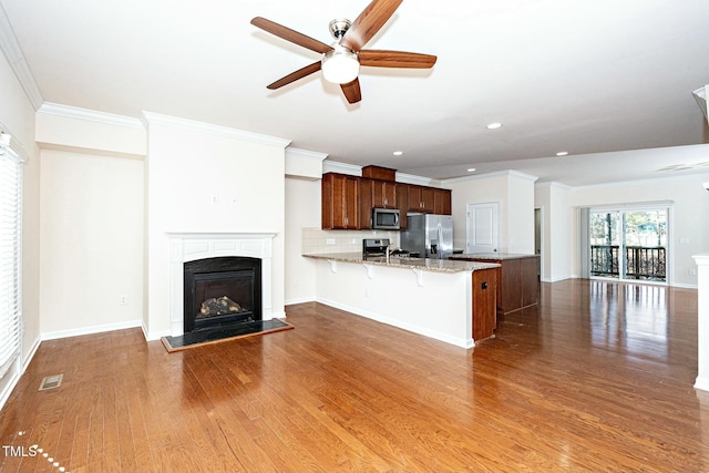 kitchen with stainless steel appliances, a peninsula, wood finished floors, visible vents, and open floor plan