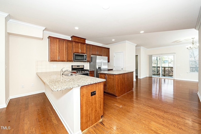 kitchen featuring a center island, stainless steel appliances, tasteful backsplash, light wood-style flooring, and a sink