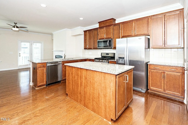 kitchen featuring dark wood finished floors, appliances with stainless steel finishes, ornamental molding, a sink, and a peninsula