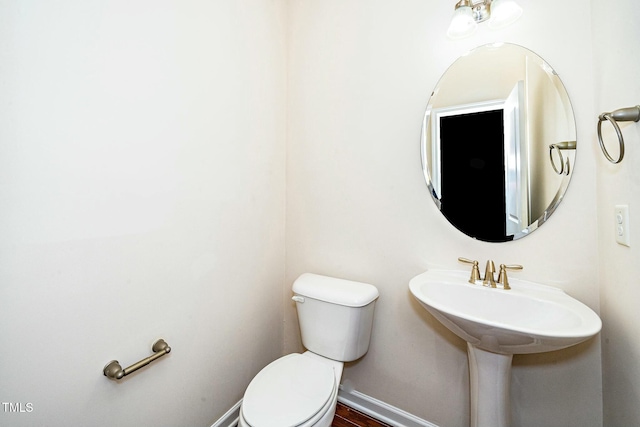 half bath with toilet and baseboards