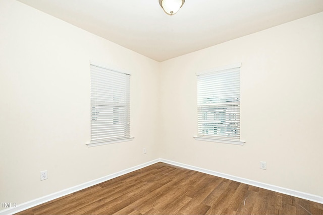 empty room featuring baseboards and wood finished floors