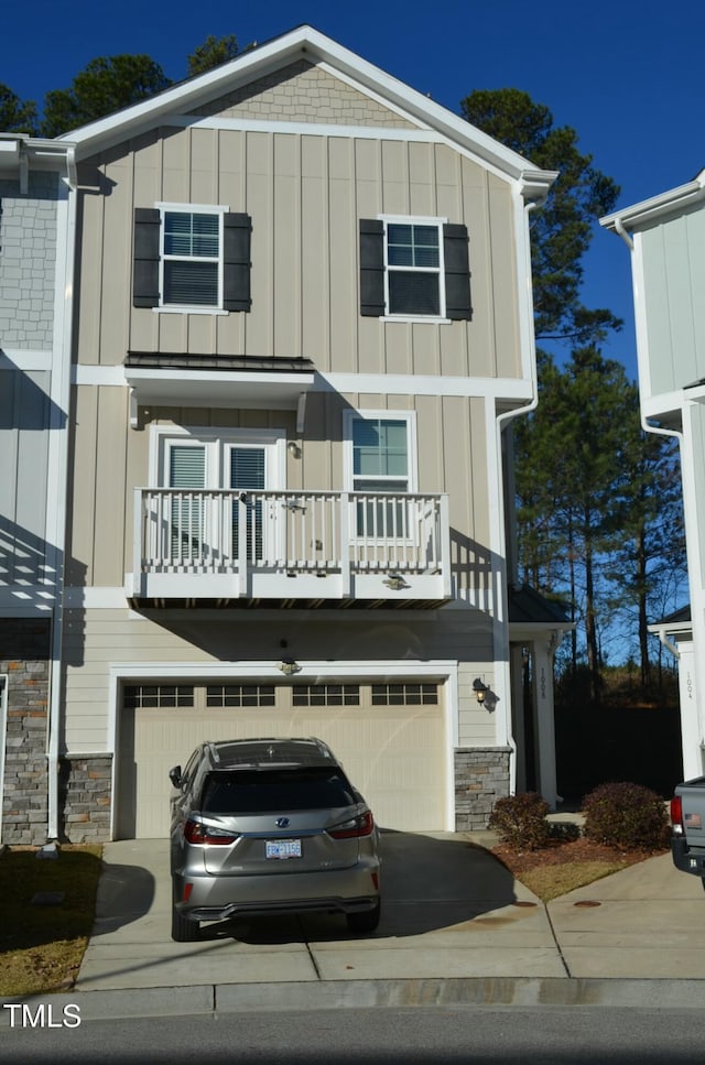 view of front of home featuring a garage, stone siding, board and batten siding, and driveway