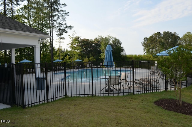 community pool featuring a yard, fence, and a patio