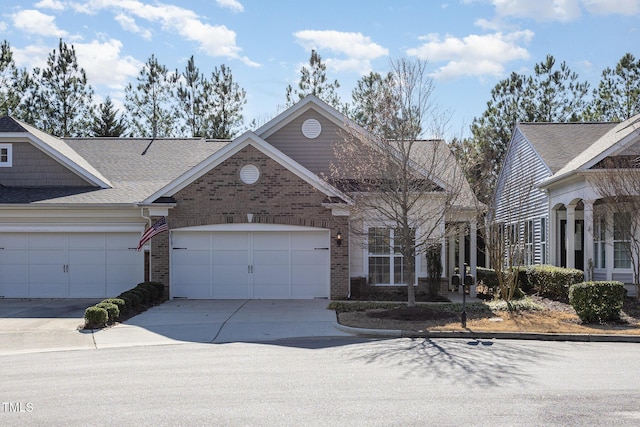 view of front of property with a garage, brick siding, driveway, and roof with shingles