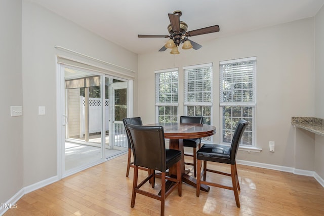 dining space with light wood finished floors, ceiling fan, and baseboards