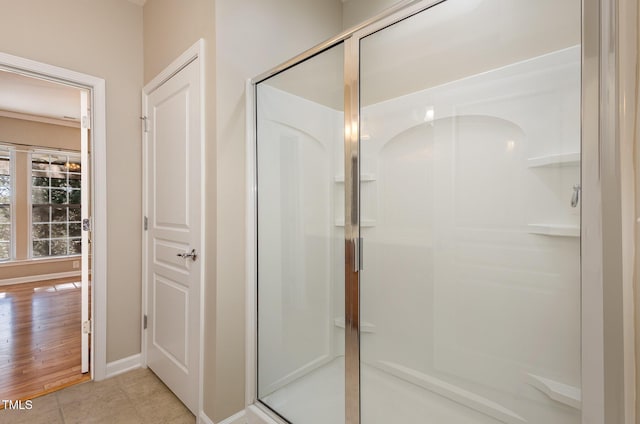 full bath featuring tile patterned flooring, a shower stall, and baseboards