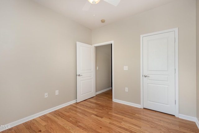 unfurnished bedroom with ceiling fan, light wood-style flooring, and baseboards