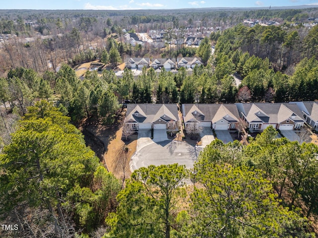 drone / aerial view featuring a residential view and a wooded view