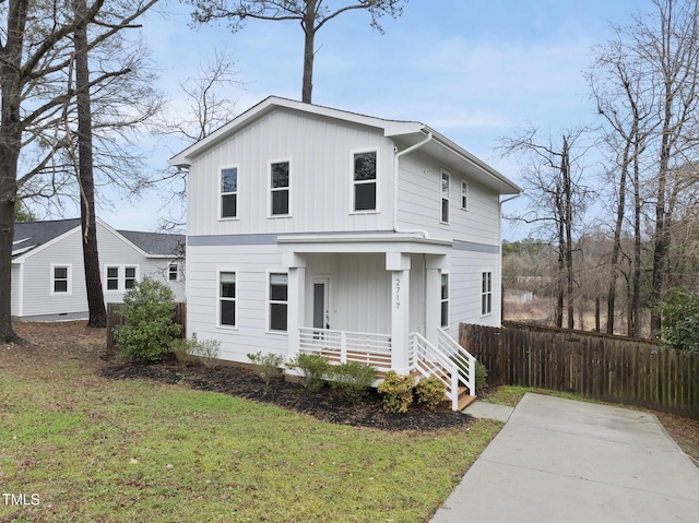 view of front of home with fence, a porch, board and batten siding, and a front yard