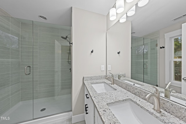 bathroom with a stall shower, visible vents, and a sink