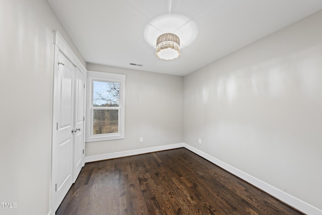 unfurnished bedroom with visible vents, baseboards, and dark wood-style flooring