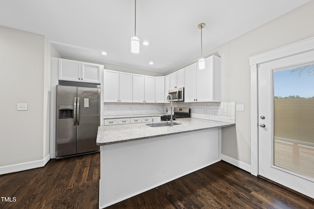 kitchen featuring stainless steel appliances, a peninsula, white cabinetry, backsplash, and light stone countertops